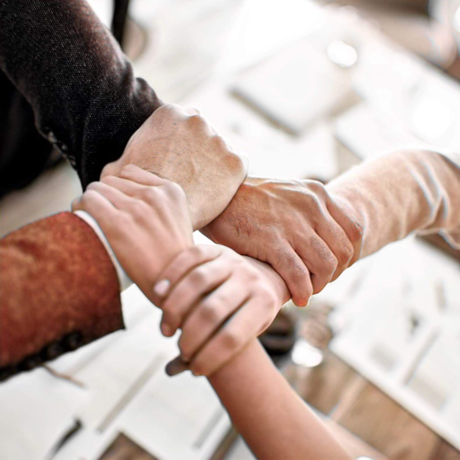 Team members' hands joined together over paperwork